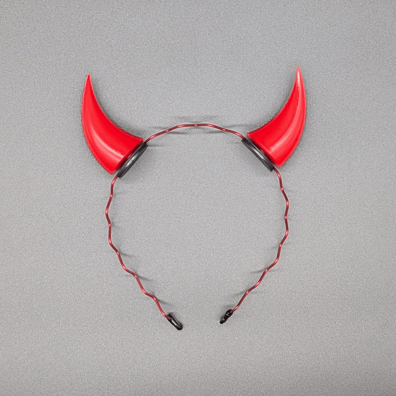 Two scarlet red incubus horns attached to a headband.