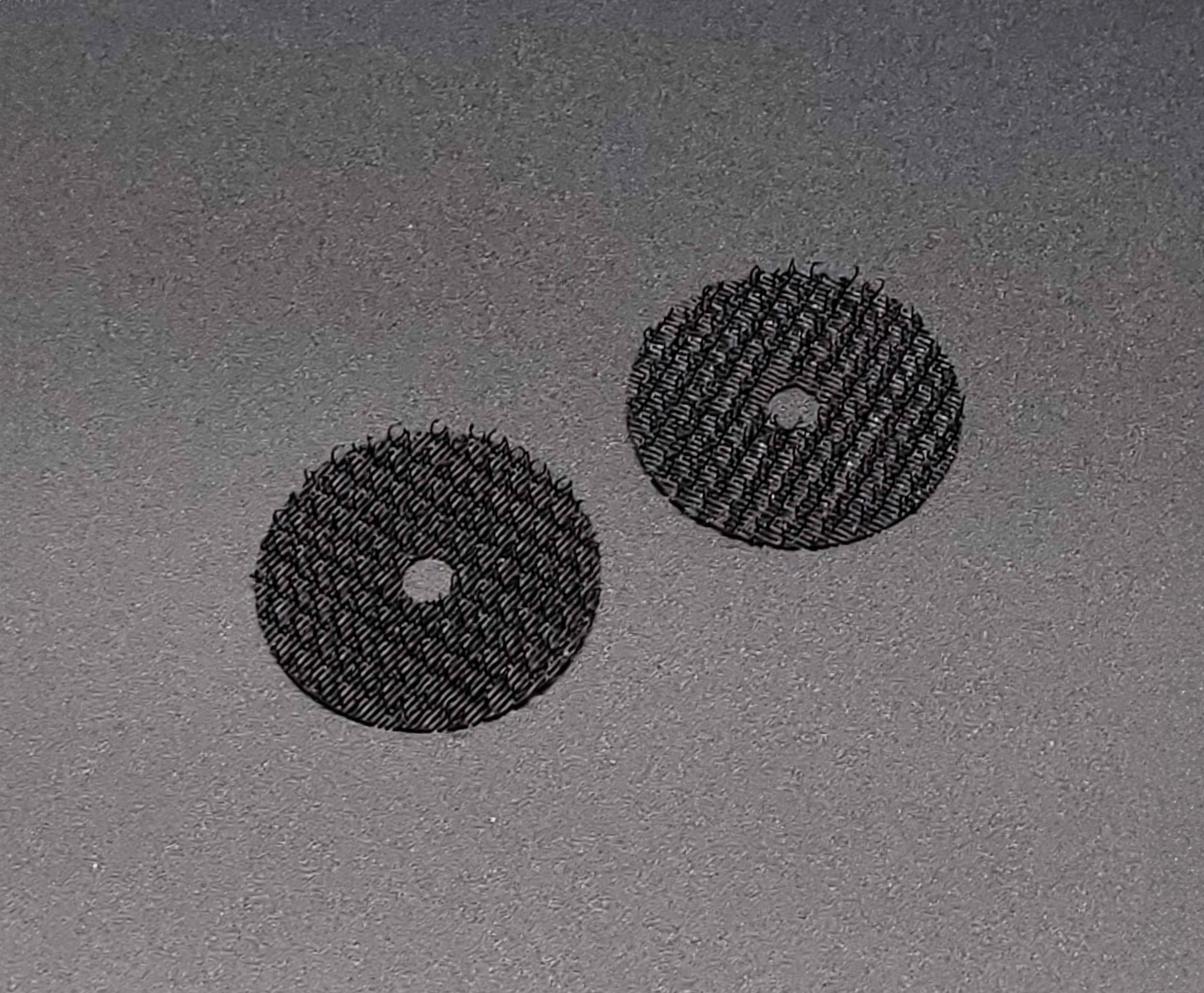 Two hook and loop discs with holes in the middle.