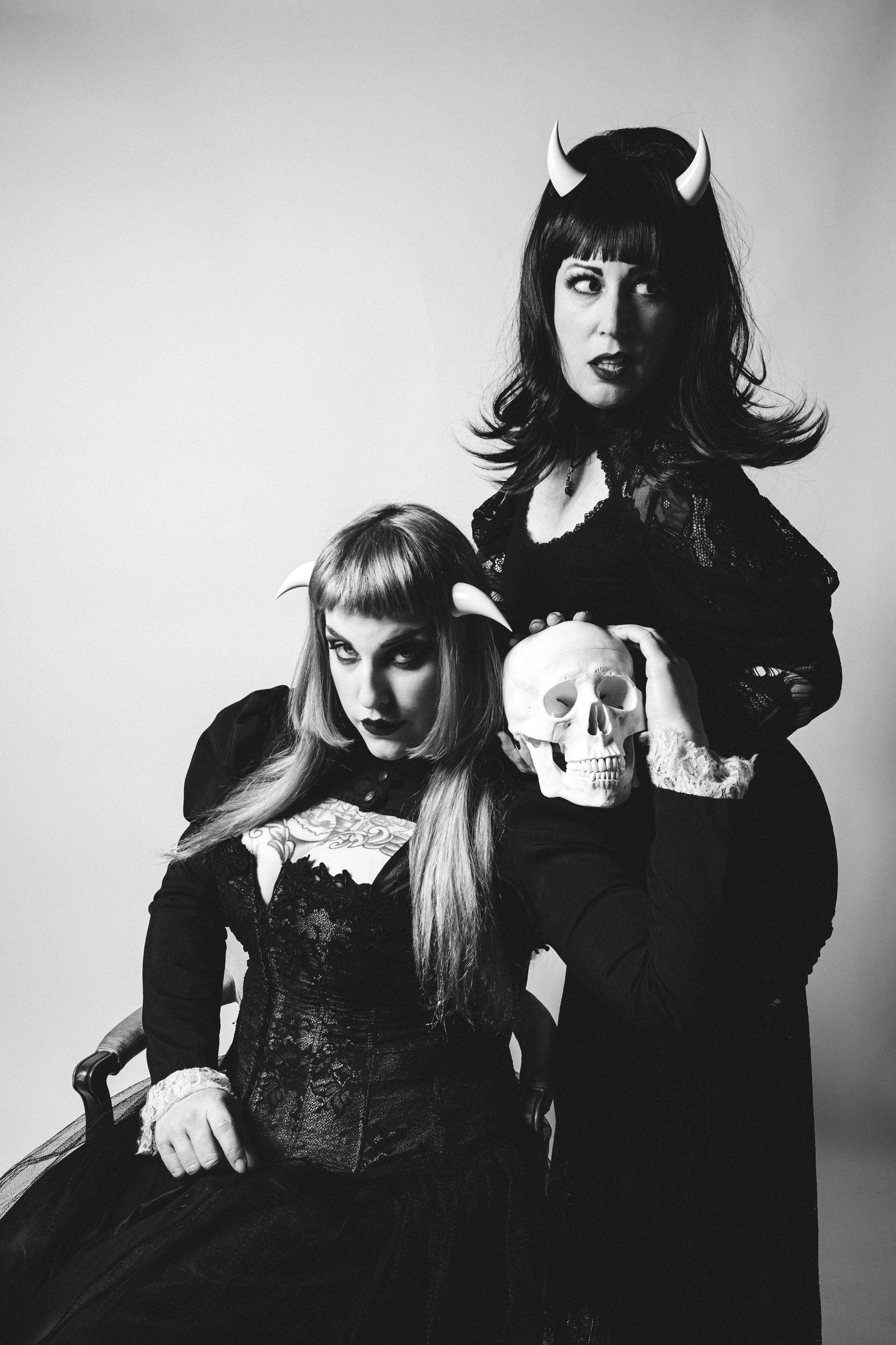 Models Stormy September and Ruby Lamb pose with a skull in gothic attire wearing bone white incubus horns. Photo by Matt Stone.