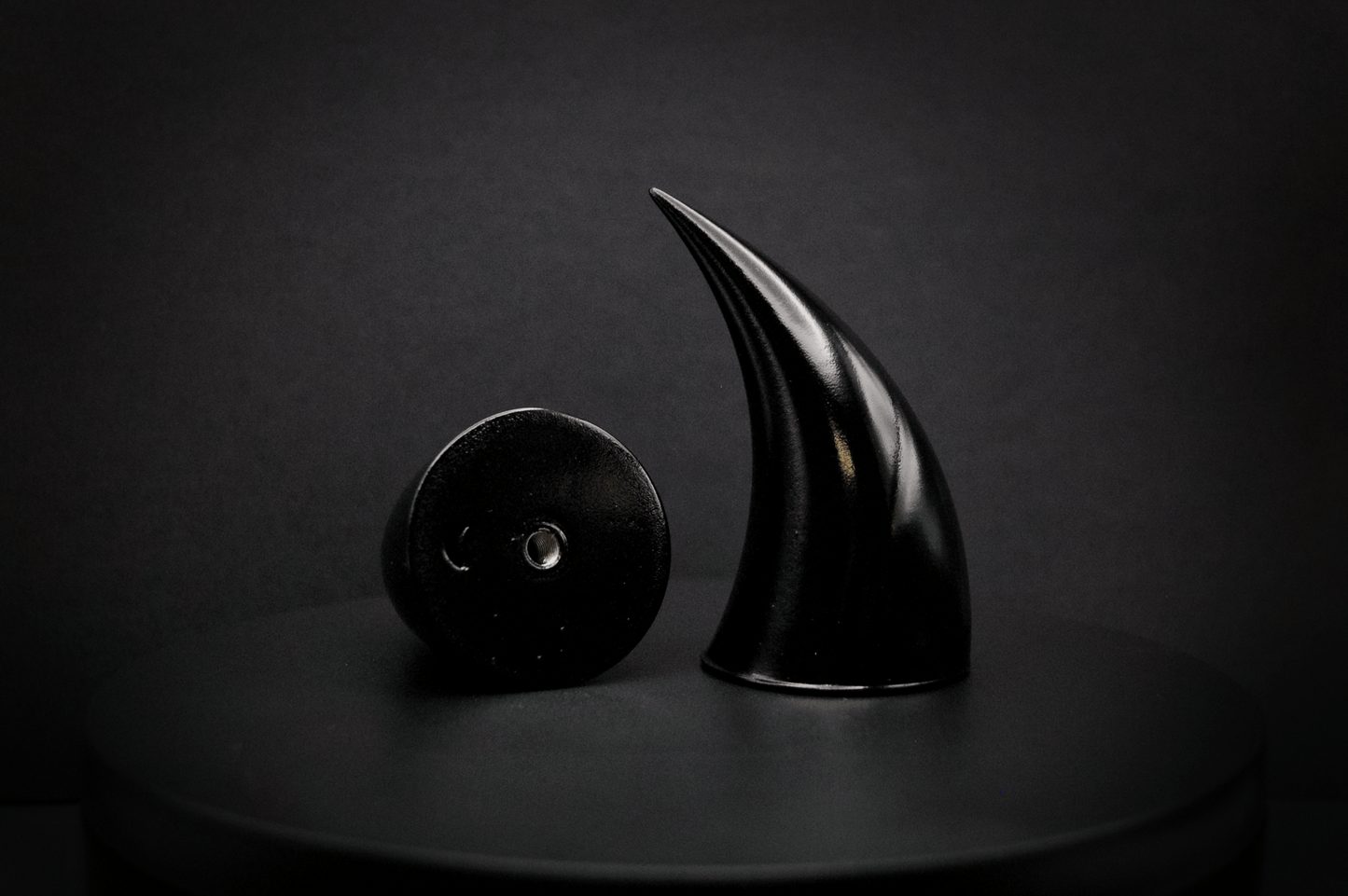 Bottom view of incubus devil horns in black with a glossy finish, showing a threaded insert on the base.