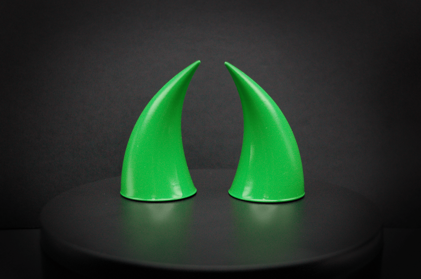 Back view of incubus devil horns in goblin green, a bright green with a glossy finish.