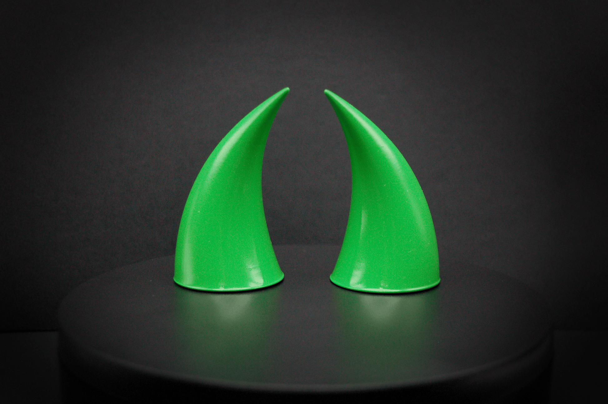 Back view of incubus devil horns in goblin green, a bright green with a glossy finish.