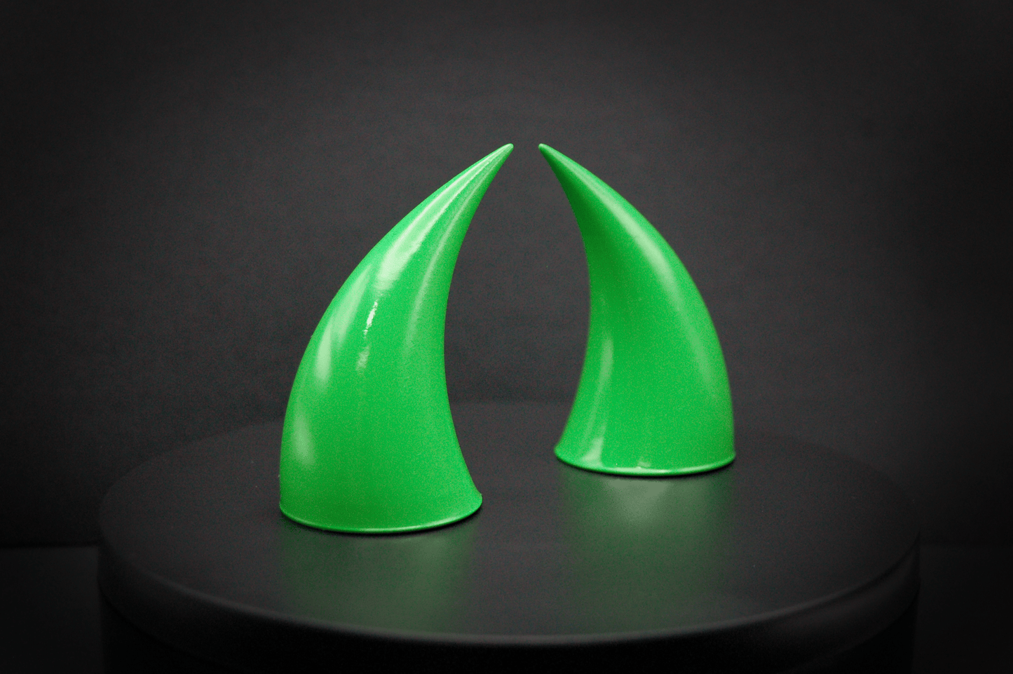 Side view of incubus devil horns in goblin green, a bright green with a glossy finish.