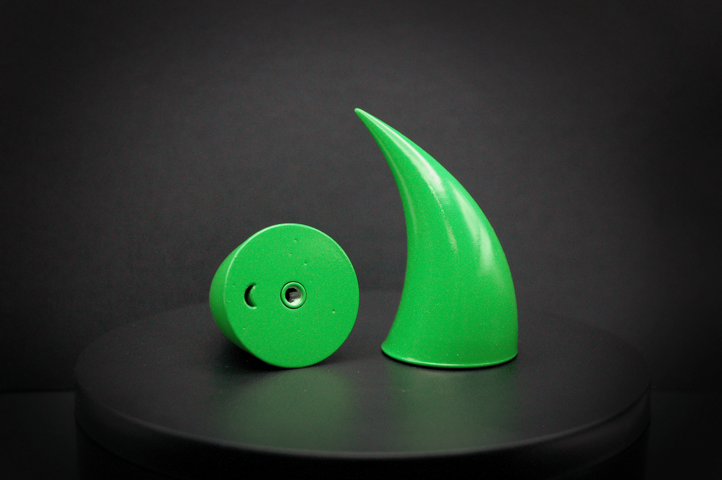 Bottom view of incubus devil horns in goblin green, a bright green with a glossy finish, showing a threaded insert on the base.